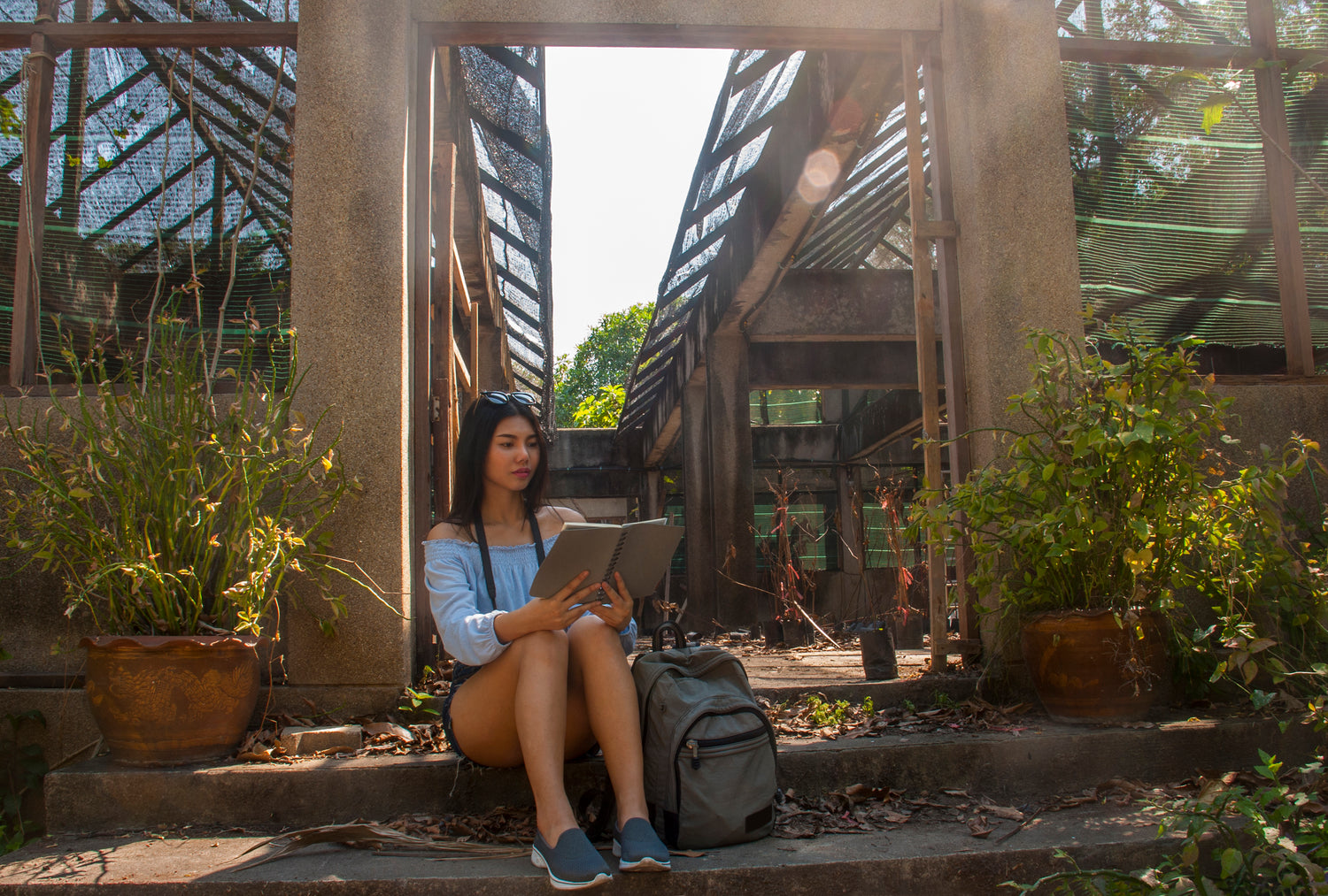 full-length-beautiful-woman-reading-book-while-sitting-steps-outdoors - verysuperb